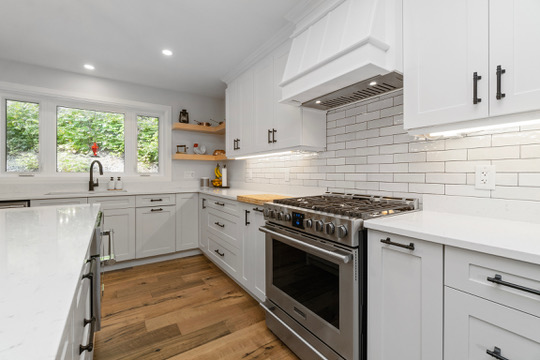 Gas range, custom hood and open shelving in the kitchen at Casa Muzyka Lakehouse